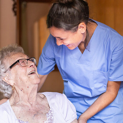 Alte Dame lacht häusliche Pflegerin an