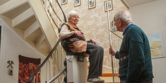 ältere Frau benutzt Treppenlift